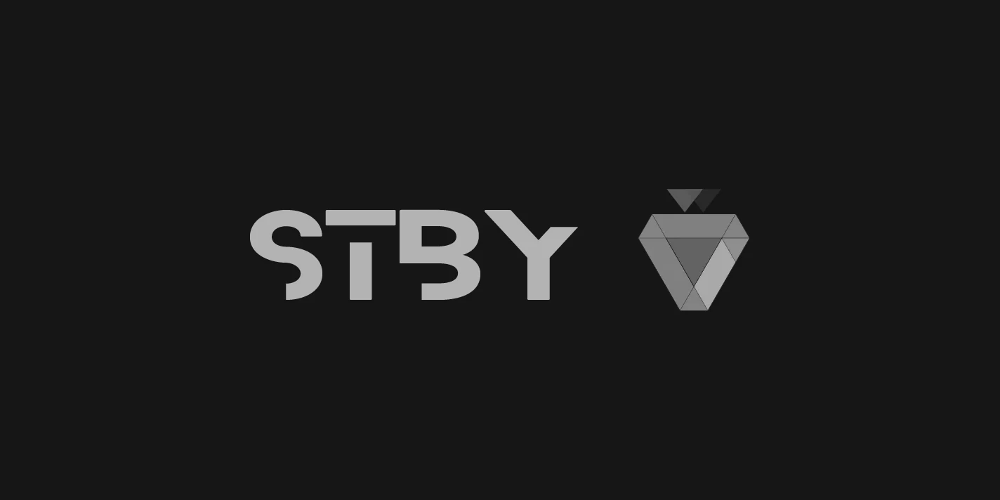 The STBY logo in grey on near-black: a geometric wordmark beside a faceted, inverted-triangle strawberry mark.