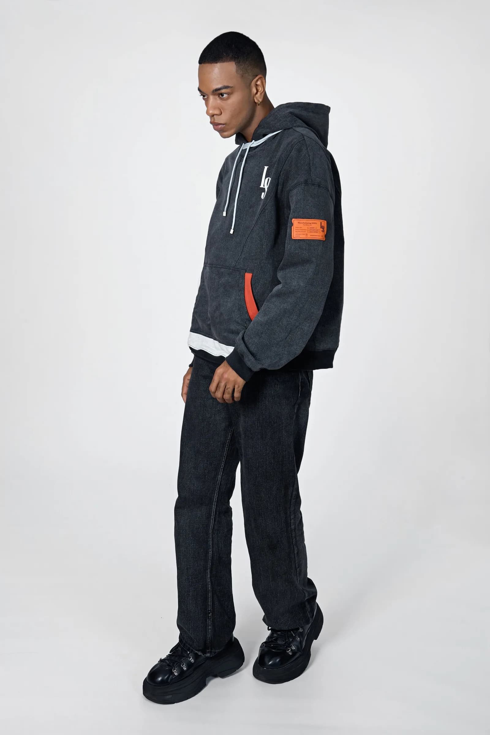 Full-length shot of the Denim Washed Hoodie with dark denim jeans and boots