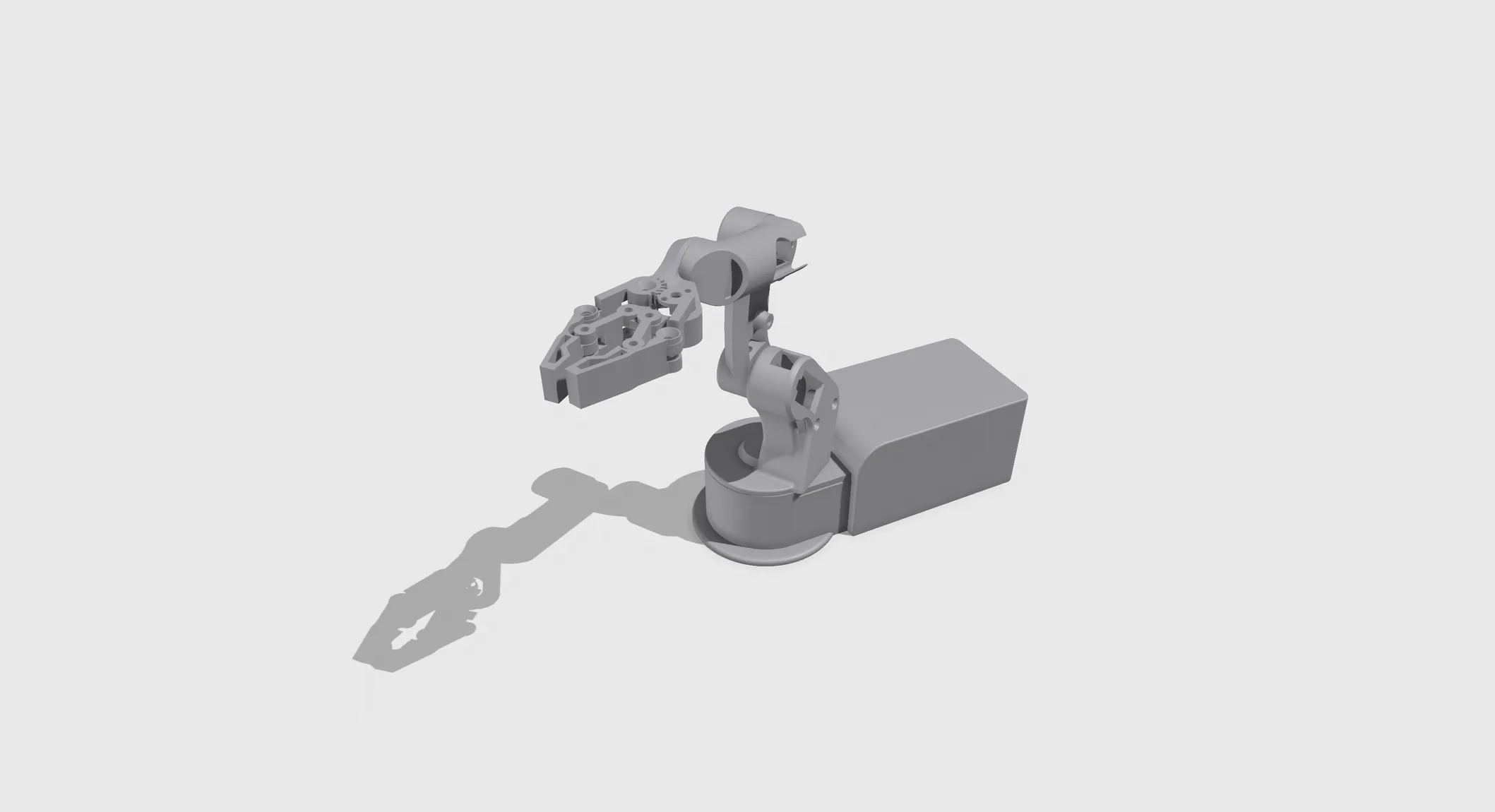 Grey CAD render, three-quarter view from above: the arm reaching forward from the round turntable, with the rectangular electronics base behind it casting a long shadow