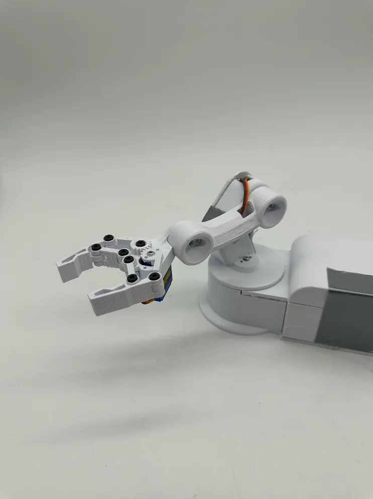 The finished arm with its claw open toward the camera, showing the gear-linked fingers and black screw heads
