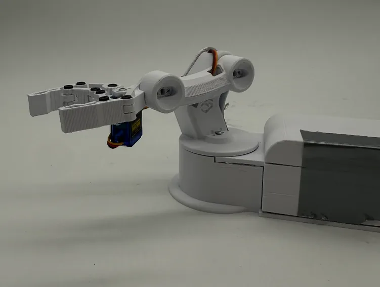 Side view of the finished arm reaching left over the turntable, with the rectangular base and a blue USB connector behind