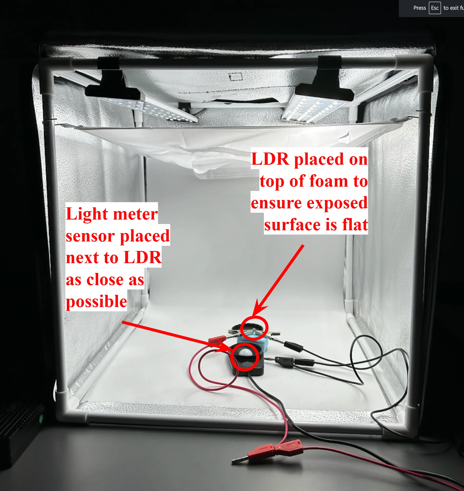 Test setup inside a lit photo light box, annotated: the LDR placed on top of foam so its exposed surface is flat, and the light-meter sensor placed as close to the LDR as possible