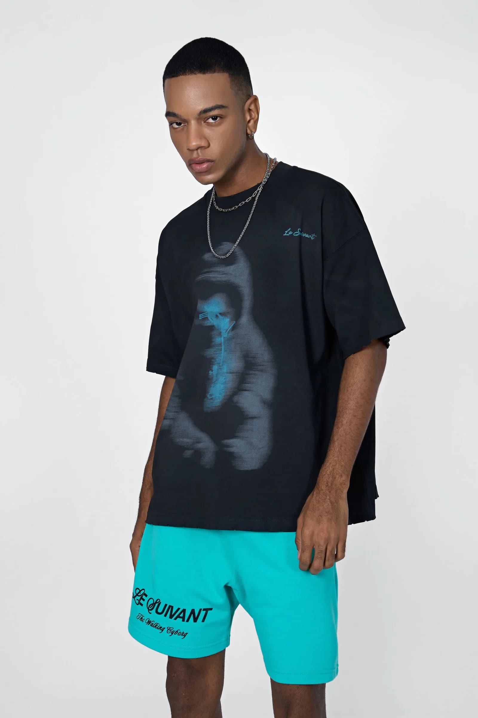 Model in the black Birth oversized washed T-shirt with the blurred baby-cyborg print, worn with cyan Cyborg Classic shorts