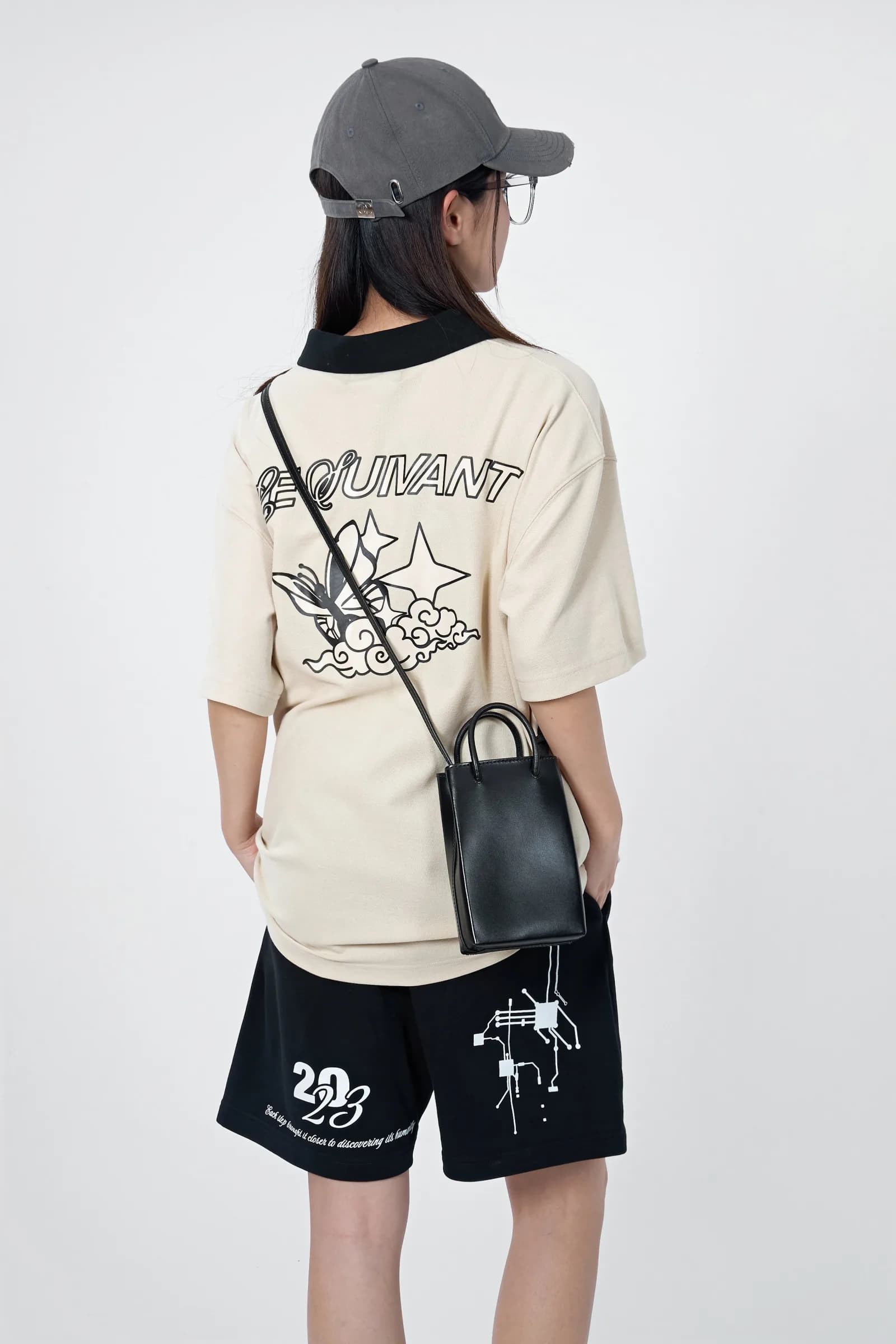 Model from behind: the Butterfly Effect polo back print with the Le Suivant script, a butterfly and a star