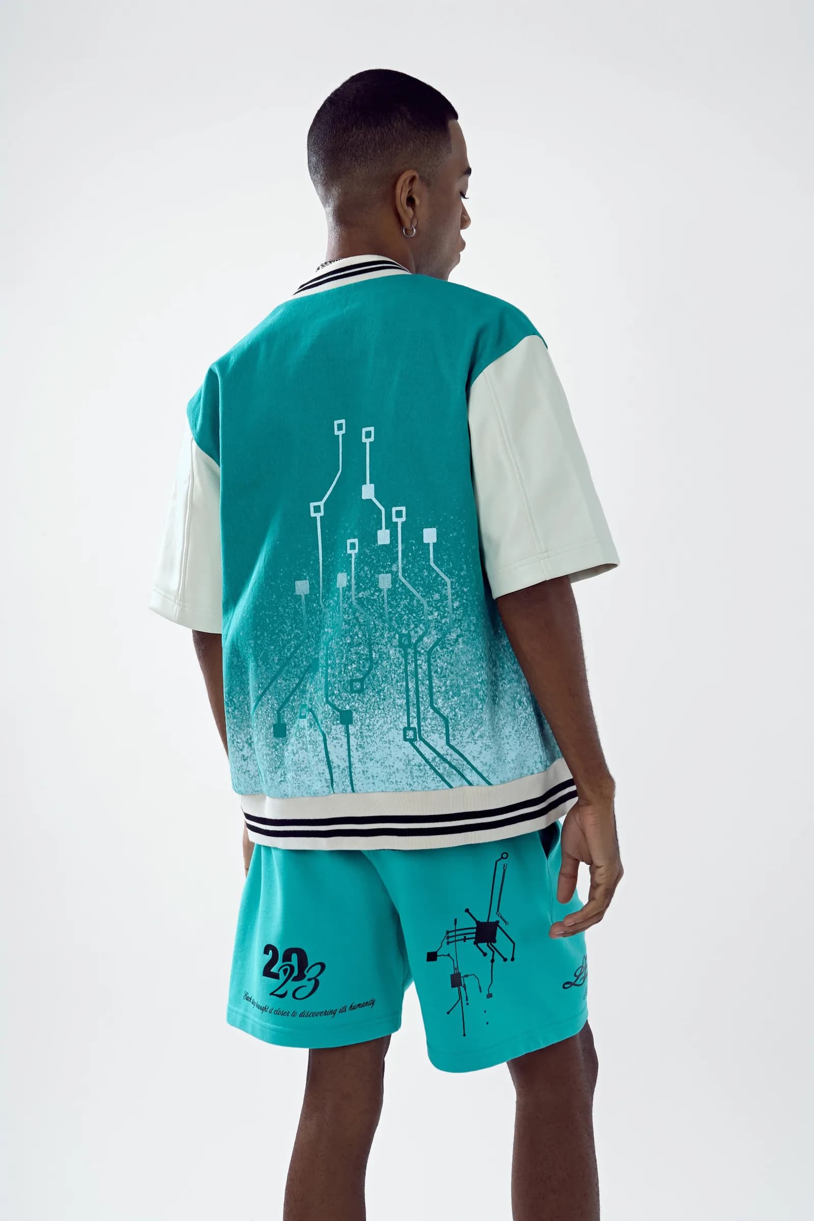 Model from behind: the Chip Body bomber’s white GPU-chip circuit print fading into cyan denim