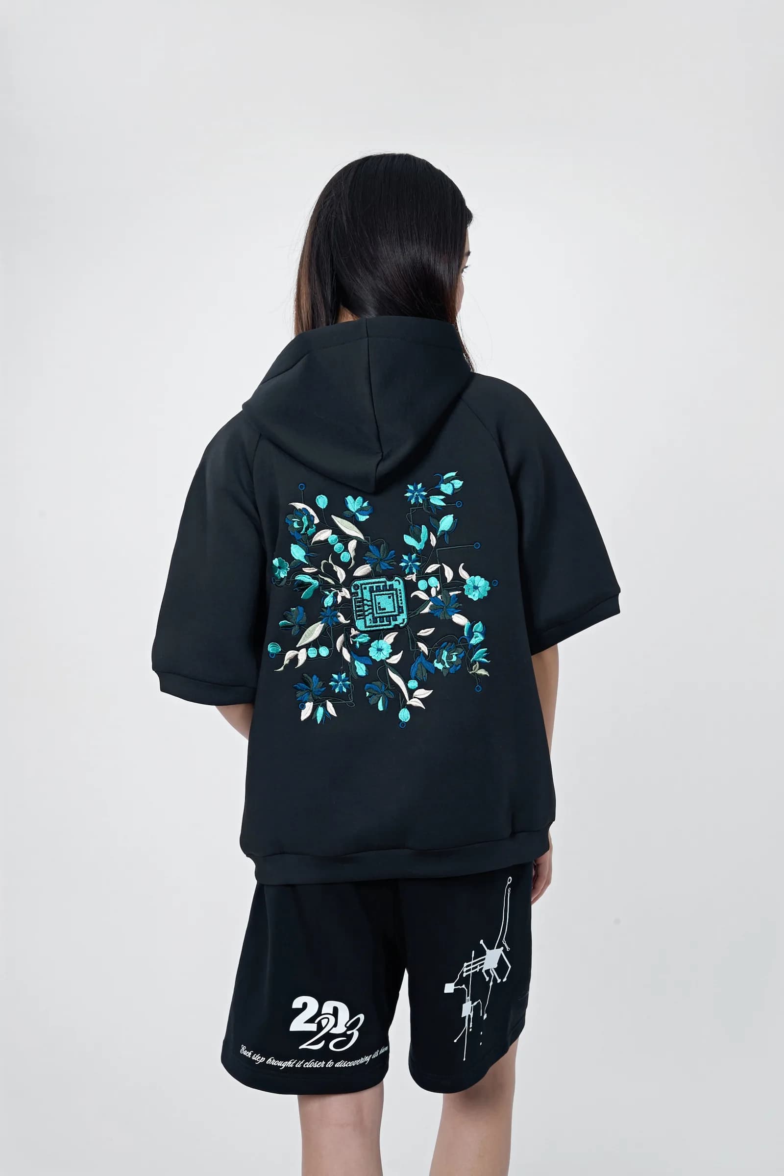 Model from behind: the Life sports jacket back with a cyan-and-white embroidered burst