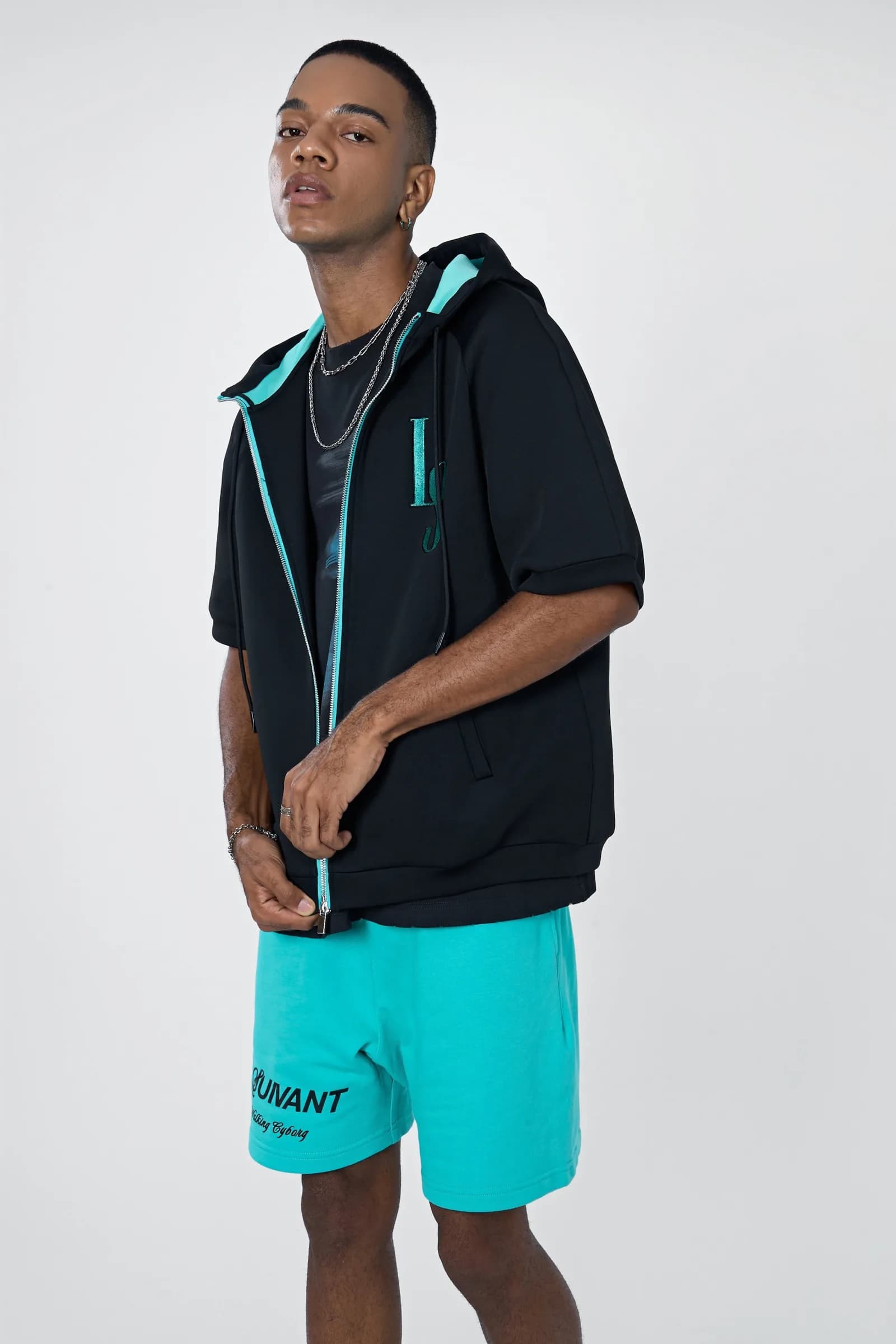 Model in the hooded Life sports jacket with a cyan zip over cyan shorts