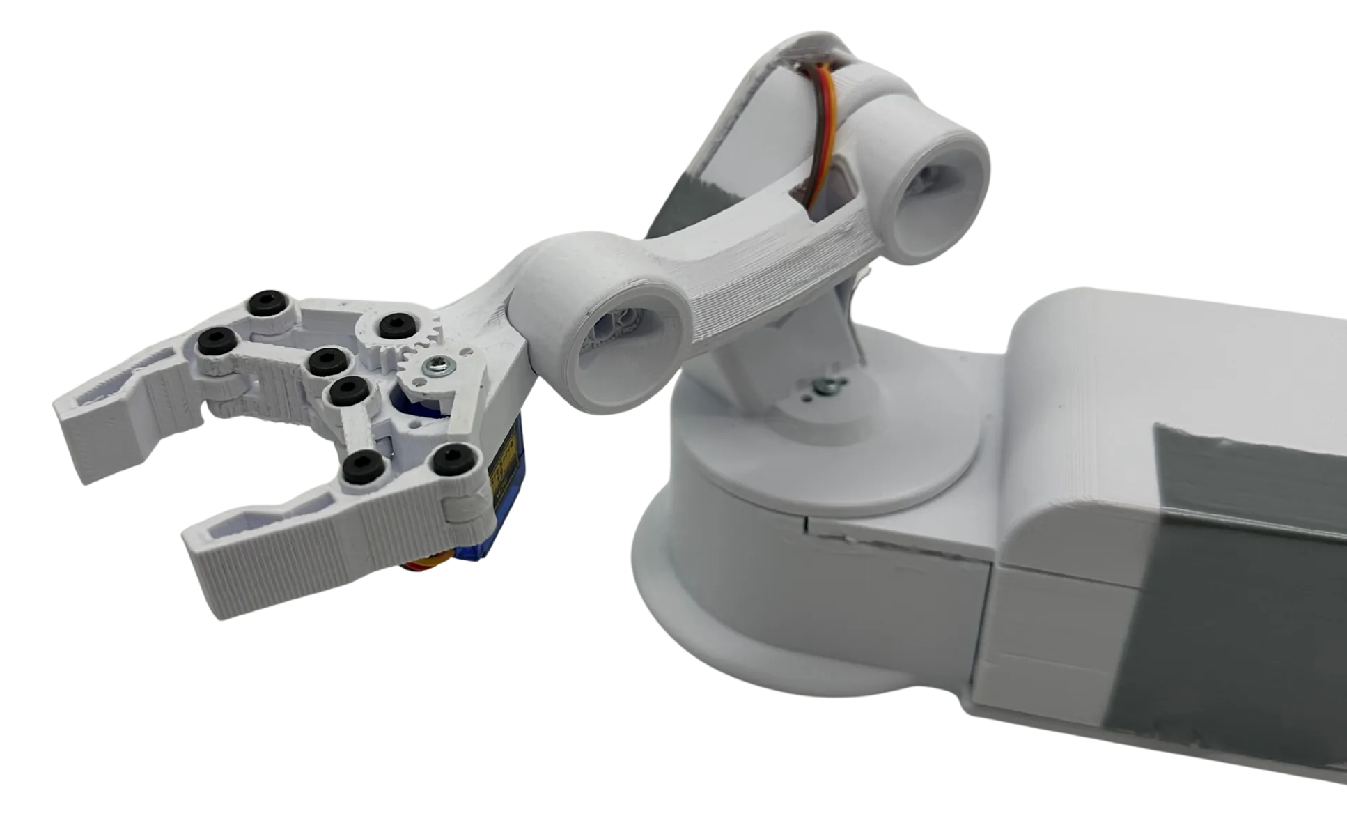 The finished robotic arm as a cut-out: a white PLA two-finger claw with black screw heads and a blue micro servo, a dog-bone forearm link with orange servo wires, and the turntable base running off the right edge